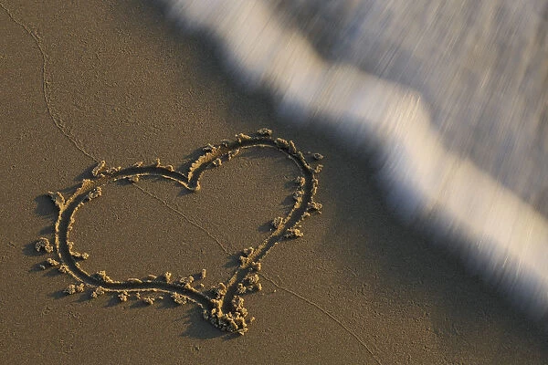 Heart in sand washed away by wave, The Netherlands, Noord-Holland