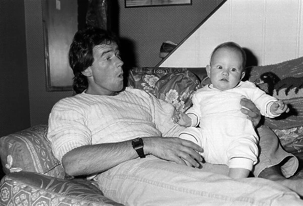 Barry Sheene with baby daughter Sidonie at home, May 1985