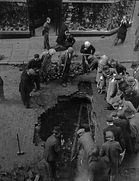 Birmingham residents inspect a bomb crater in Corporation Street, Birmingham