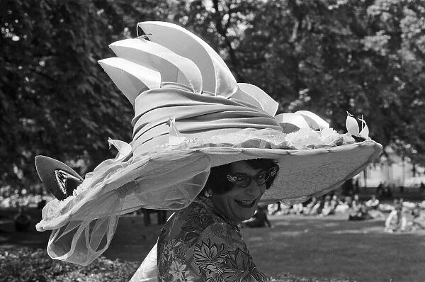 Dame Edna Everage (aka Barry Humphries) trying on her new hat for Ascot