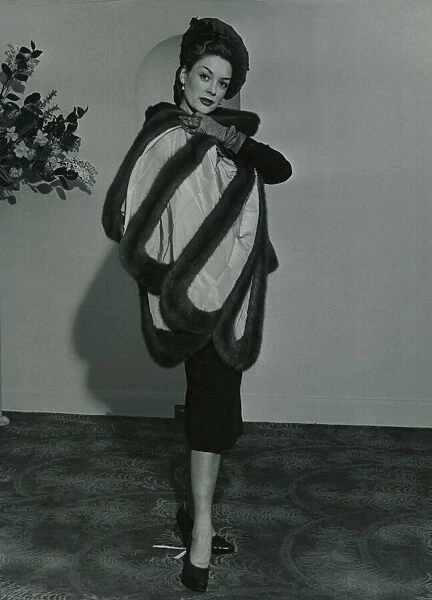 Fashion 1950s Model wearing a wild mink stole on pleated taffeta with matching gloves