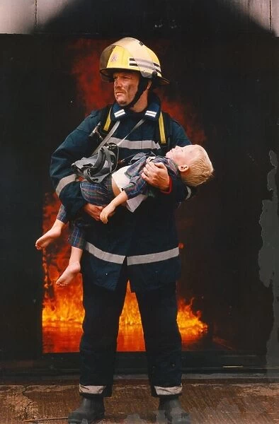 A firefighter rescus a young boy from a fire 01  /  06  /  95 circa - posed by models