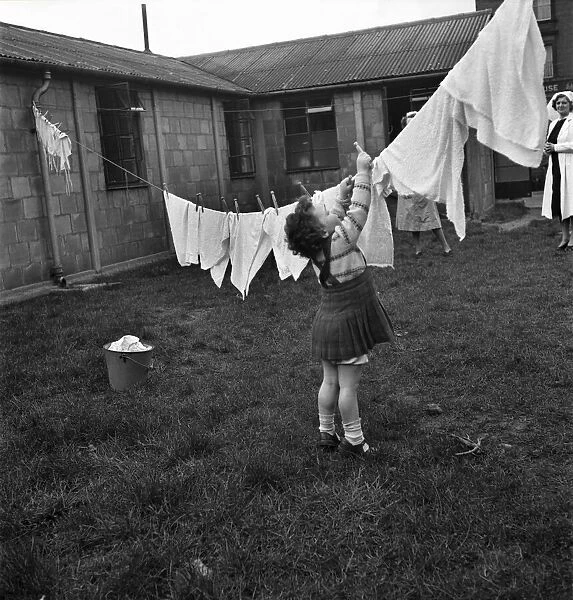 Gosforth Street day nursery, Newcastle. Eileen Potts (4) hangs out the washing