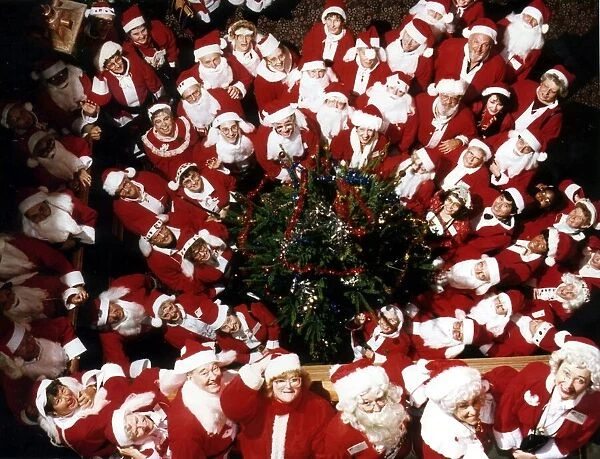 A group of Santas pose at a Christmas party. 19th December 1991
