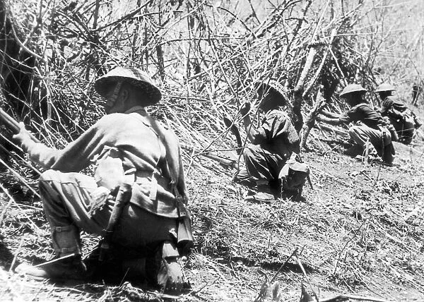 Gurkha soldiers in position cut bamboo stakes to protect their newly won positions during