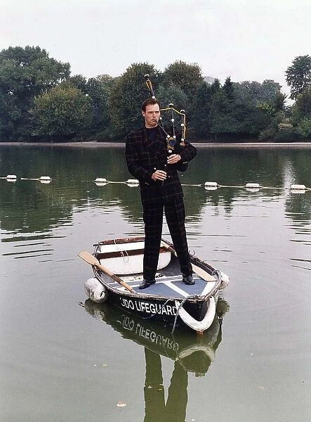 John Leslie TV Presenter standing in a rowing boat wearing a tartan suit