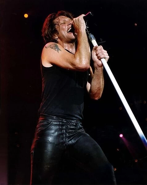 Jon Bon Jovi Pop Singer for Bon Jovi group on stage singing into microphone