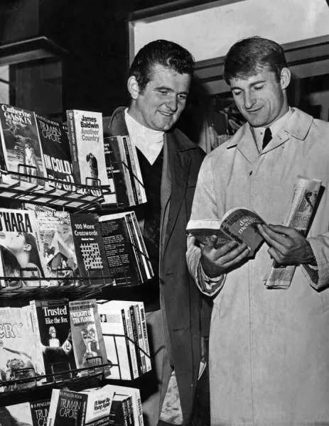 Liverpool footballers Tommy Lawrence and Roger Hunt looking through books at a stall in