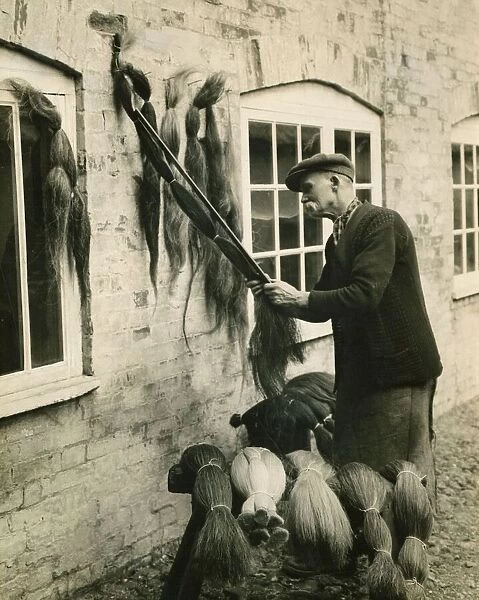 A man measuring lengths of horse hair for use in the weaving industry August 1930