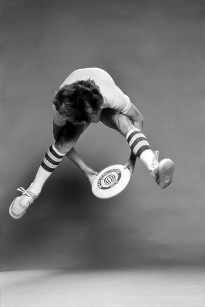 A man performing exercises with a frisbee. June 1980