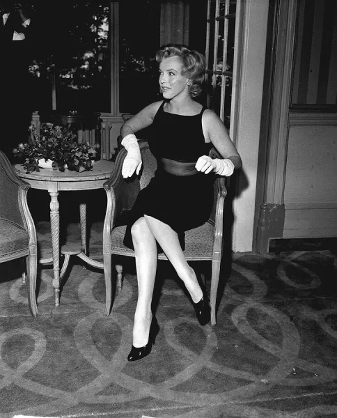 Marilyn Monroe sitting on a chair in her hotel foyer for Mirror Feature by Donal Zec