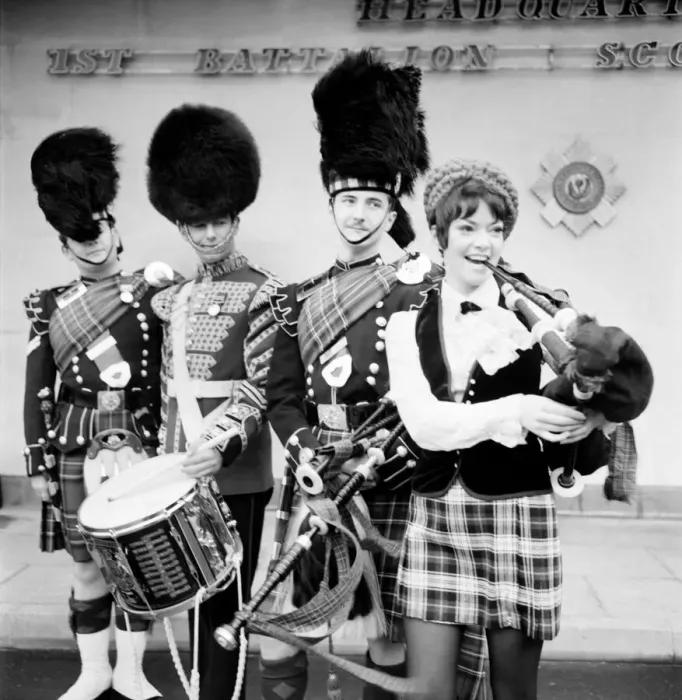 Framed Print : Black and white print of a young woman attempting to play the bagpipes
