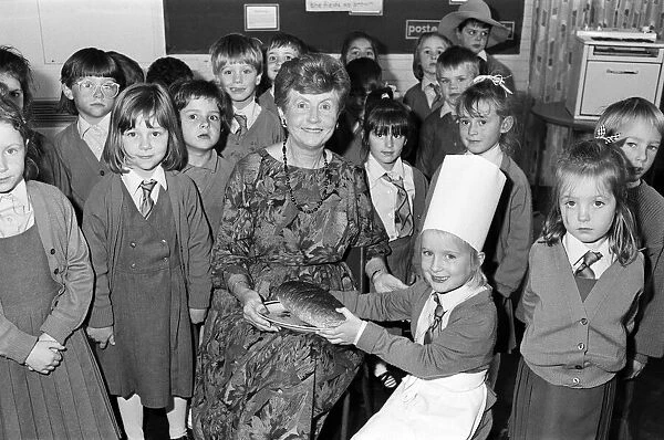 Mrs Rita Manchester receives a loaf of bread from six-year old Angela Chapman after a