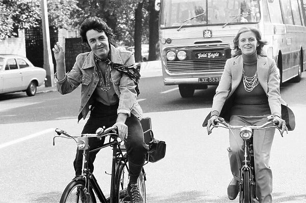 Paul McCartney and wife Linda McCartney riding bicycles in London
