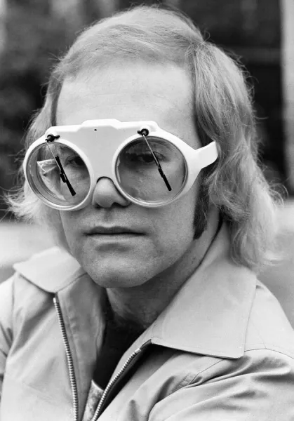 Pop singer Elton John at his home at Virginia Water. His glasses have window screen