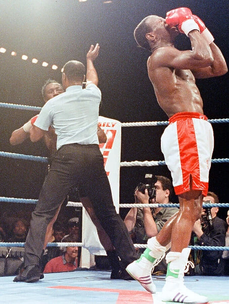 The referee stops the bout as Chris Eubank celebrates his victory over Nigel Benn