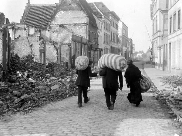 Refugees carry their belongings with them as they flee the fighting during the Battle of