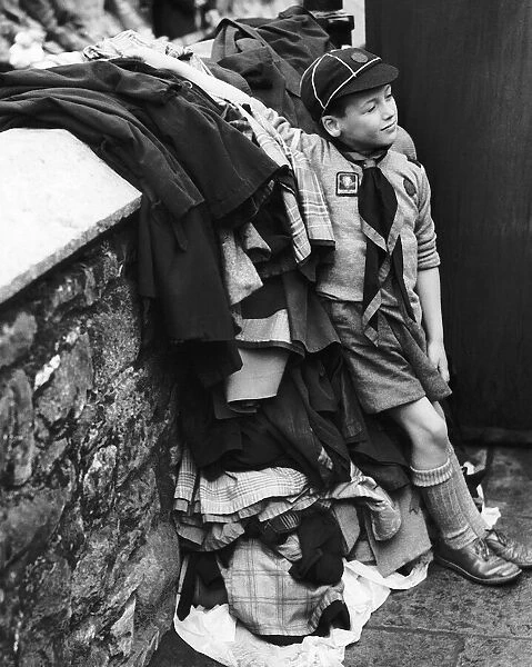 Scouts Peter Roberts aged 8 guards a pile of coats as his pack take part in a carnival