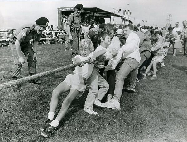 Soldiers encourage youngsters to get their backs into a tug-of-war in July 1987 at