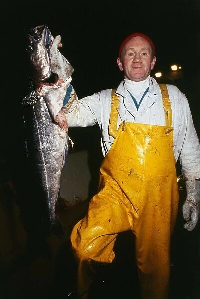 Stanley Robinson fisherman wearing yellow overalls holding