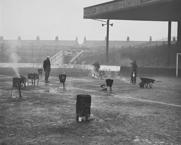 A team of four men thaw out Manchester City Football ground with braziers