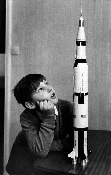 Toys-Space Rockets: Paul Ward of Belgravia, studies a model of the Apollo 12 rocket