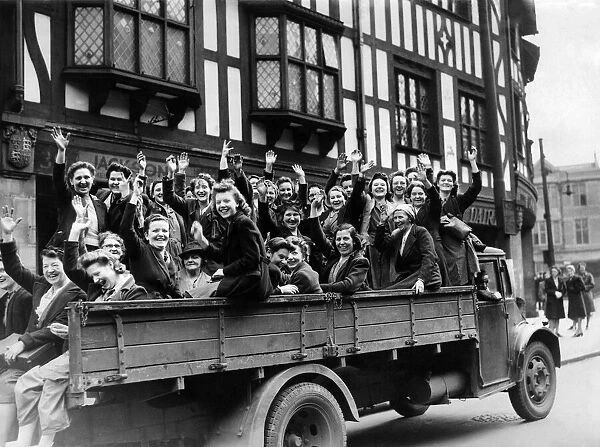 Women munition workers waving cheerfully as they move away to their factory on an army