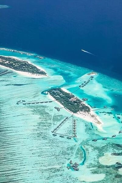 Amazing bird eyes view in Maldives from plane or drone. Luxury resort hotel water villas bungalows. Summer vacation holiday landscape destination