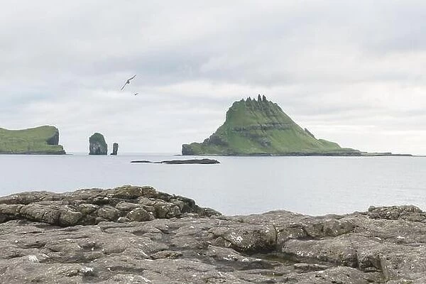 Dramatic view on Drangarnir and Tindholmur sea stacks in Atlantic ocean from Vagar island, Faroe Islands. Landscape photography