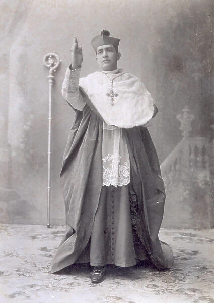 Full-length portrait of a Bishop. He is posing in the studio in the act of giving a blessing