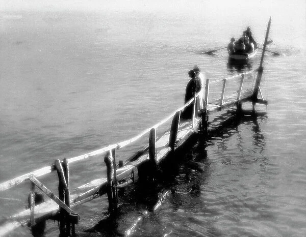 'The Landing' A man and a woman on a landing watch a boat with a few people aboard