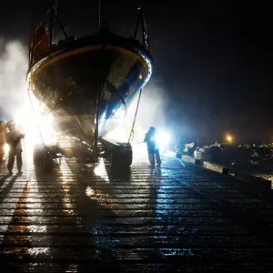 Hoylake mersey class lifeboat Lady of Hilbre 12-005 being washed down by shore crew on the slipway at night. Taken from The Lifeboat: Courage on our Coasts. Page 37