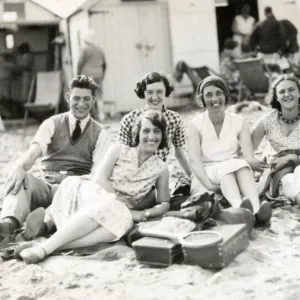 Beach party in front of beach huts, Paignton, Devon