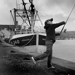 Boy casts his fishing line into River Dee at Kirkcudbright