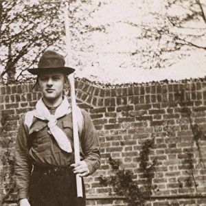 Boy in scout uniform in garden, Ealing, West London