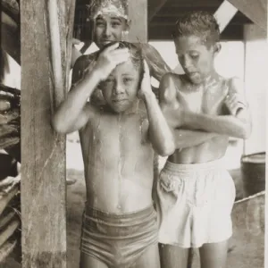 Boy scouts sharing a shower at camp, British Honduras