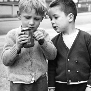 Two boys with jam jar on a Balham street, SW London
