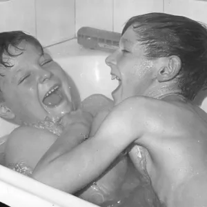 Two boys larking about in the bath