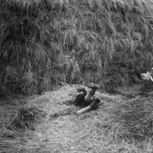 Two boys playing near a haystack