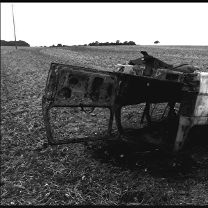 Burnt out car abandoned in a field