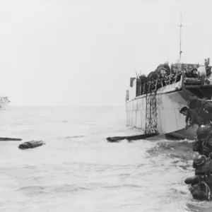 Commandos wade ashore from landing craft at Juno beach