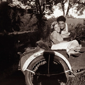 Couple together with1948 Harley Davidson motorcycle sidecar