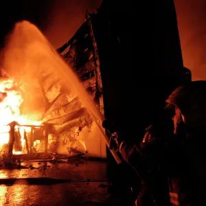 Firefighters working at scene of large warehouse fire