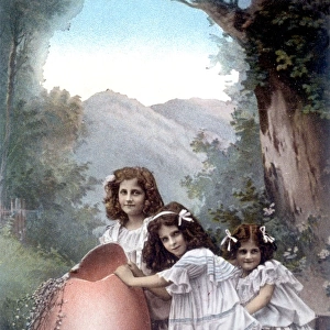 Three little girls with a large Easter egg on a trolley