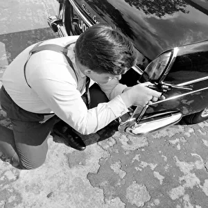 Policeman aiming his gun round the side of a car during training at the Police Gun School
