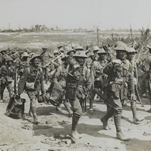 Vickers machine-gun team marching past a working party