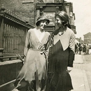 Two women walking together along a street