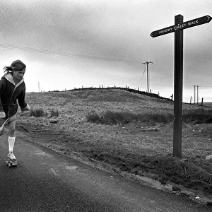 Young girl rollerskating past Sirhowy Valley Walk sign