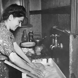 Young woman washing clothes at a sink