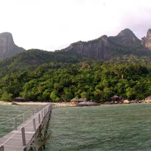 Rainforest, volcanic "Twin Peaks" - Bukit Batu Sirau and Bukit Semukut peaks, and the Gunung Kajang peak on the left, a jetty and a wooden cabins of the "Bagus Place Retreat" - a small private resort